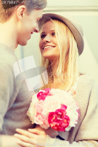 Image of happy couple with flowers in the city