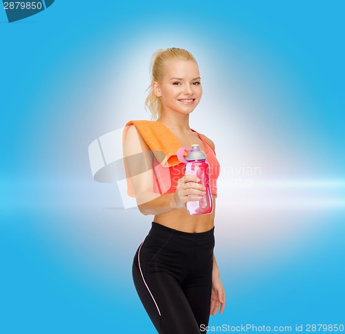 Image of smiling sporty woman with water bottle and towel
