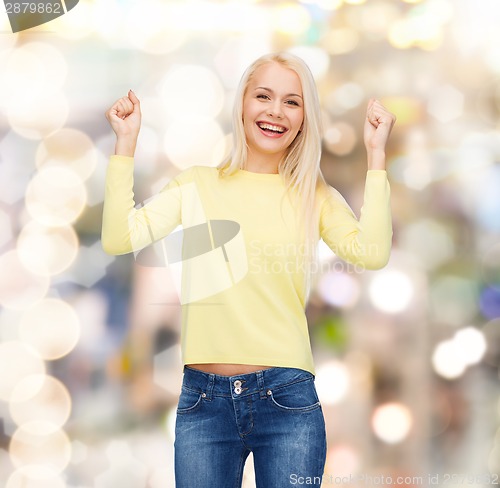 Image of laughing young woman with hands up