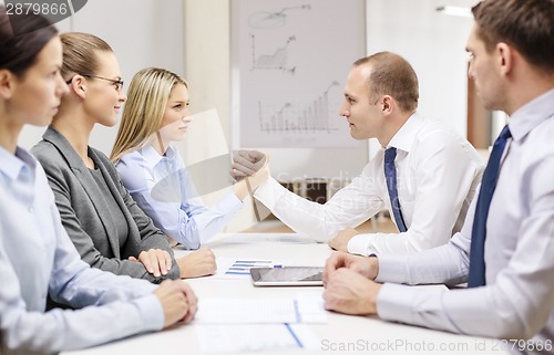 Image of businesswoman and businessman arm wrestling