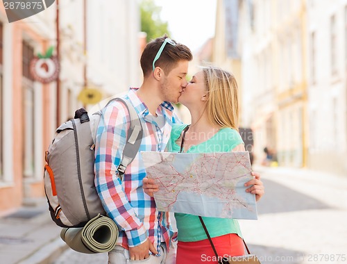 Image of smiling couple with map and backpack in city