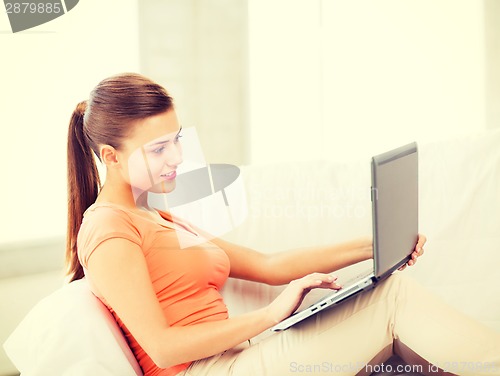 Image of happy woman using laptop at home
