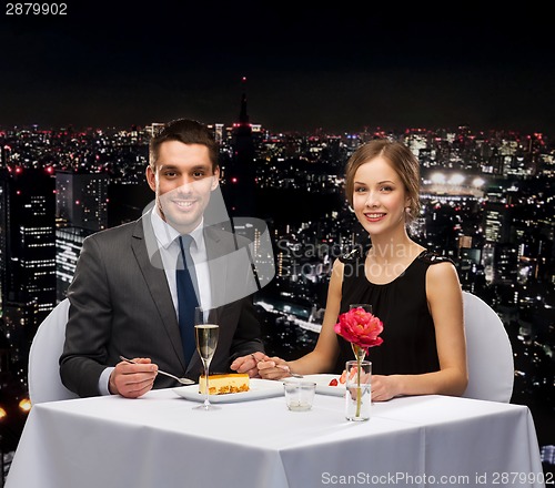 Image of smiling couple eating dessert at restaurant