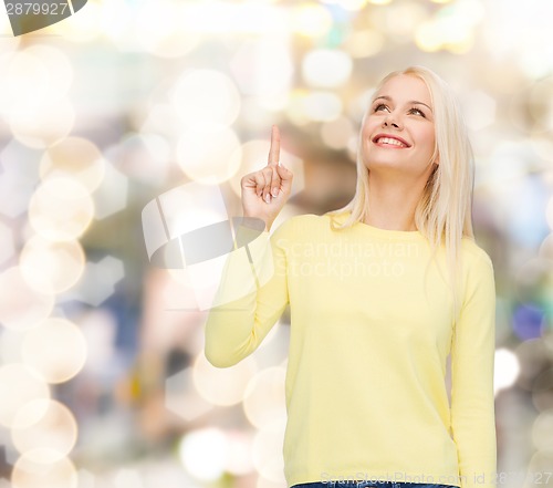 Image of smiling woman pointing her finger up