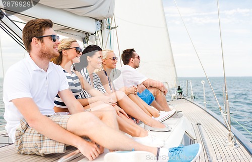 Image of smiling friends sitting on yacht deck