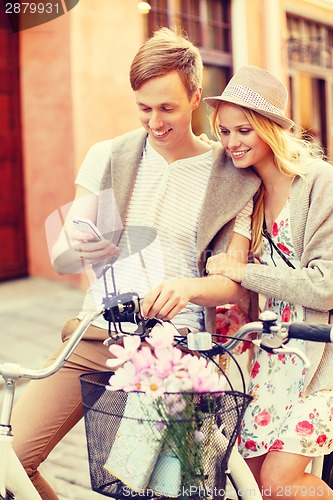 Image of couple with smartphone and bicycles in the city