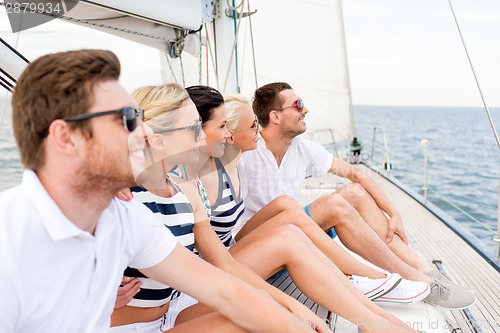 Image of smiling friends sitting on yacht deck