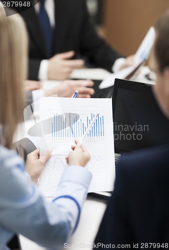 Image of close up of chats, laptop and graphs in office