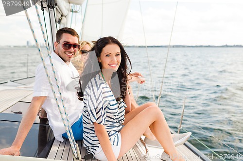 Image of smiling friends sitting on yacht deck