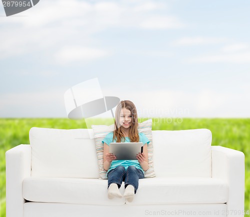 Image of little girl sitting on sofa with tablet pc