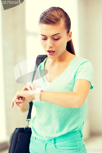 Image of surprised student girl looking at clock