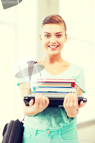 Image of student with folders and school bag in college