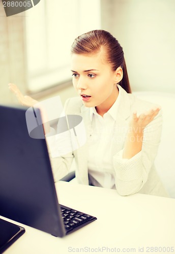 Image of stressed student with computer in office