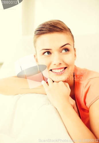 Image of smiling woman lying on the couch