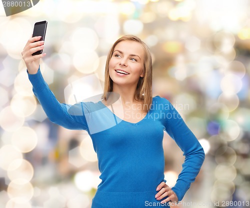 Image of woman taking self picture with smartphone camera