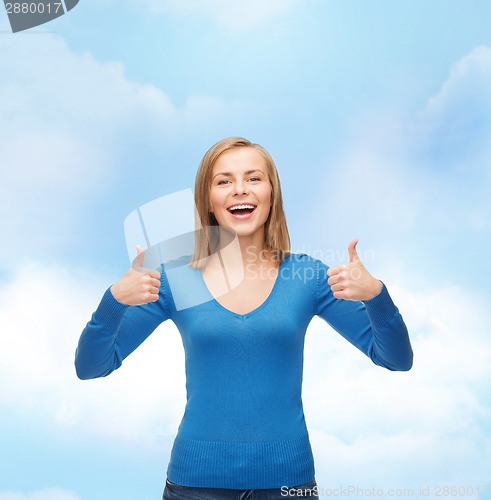 Image of smiling girl in casual clothes showing thumbs up