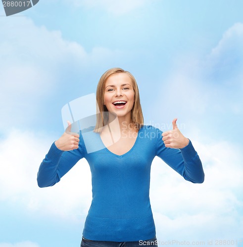Image of smiling girl in casual clothes showing thumbs up