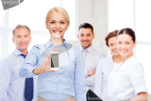 Image of smiling businesswoman with smartphone blank screen