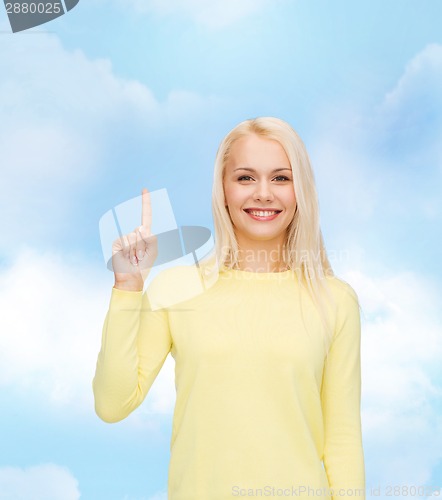 Image of smiling woman pointing her finger up