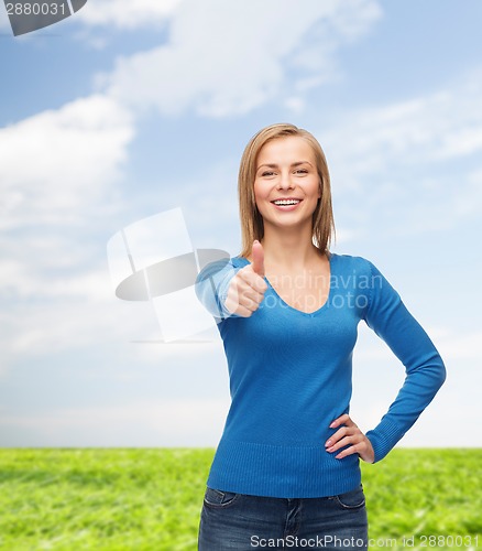 Image of smiling girl in casual clothes showing thumbs up