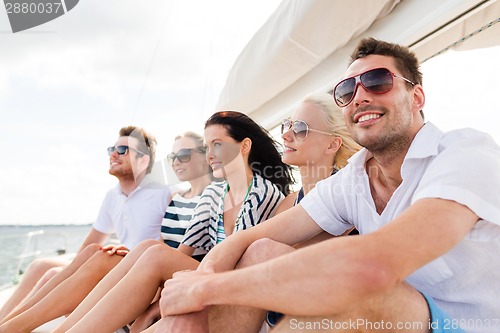 Image of smiling friends sitting on yacht deck