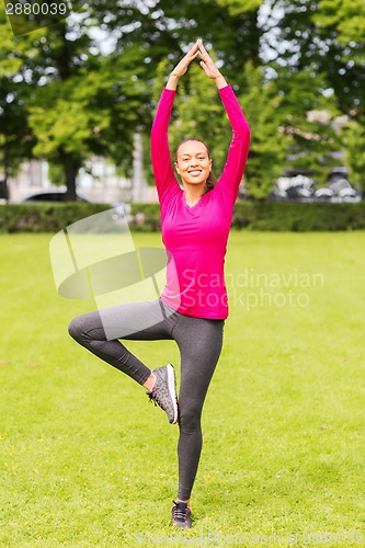 Image of smiling woman exercising outdoors