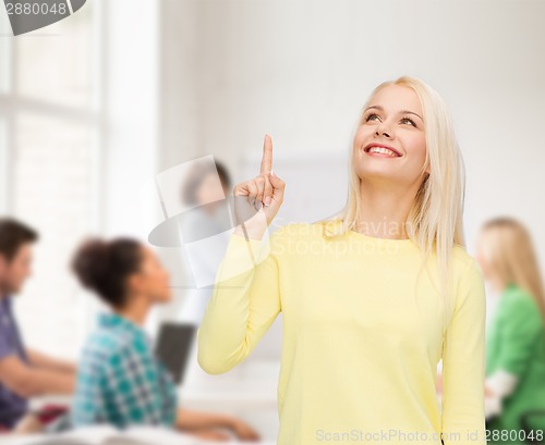 Image of smiling woman pointing her finger up