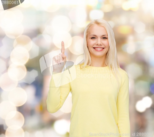 Image of smiling woman pointing her finger up