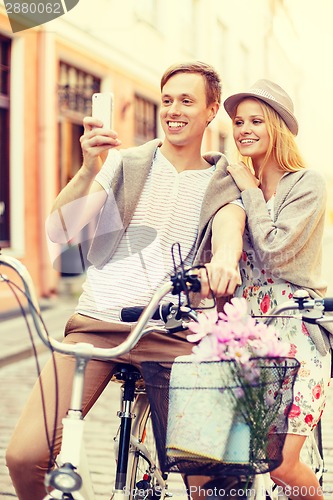 Image of couple with bicycles and smartphone in the city