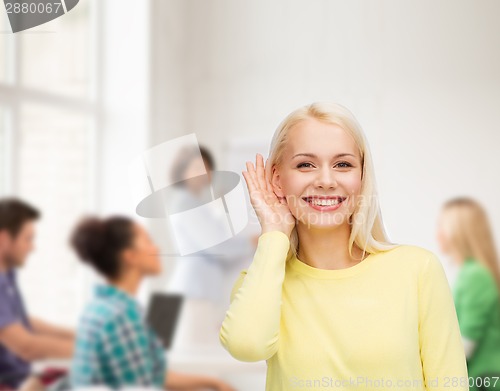 Image of smiling young woman listening to gossip