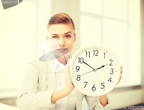 Image of attractive businesswoman showing white clock
