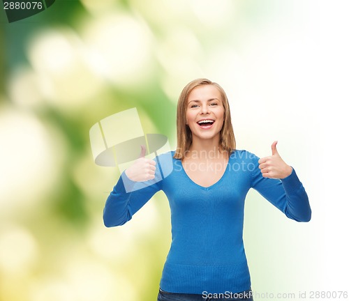 Image of smiling girl in casual clothes showing thumbs up