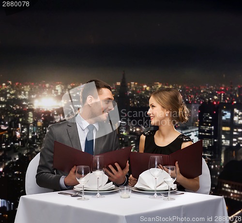 Image of smiling couple with menus at restaurant