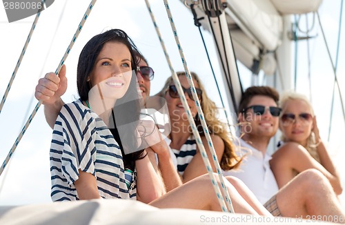 Image of smiling friends sitting on yacht deck