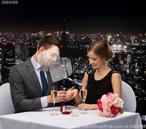 Image of man proposing to his girlfriend at restaurant