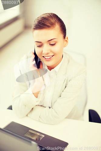 Image of businesswoman with smartphone in office