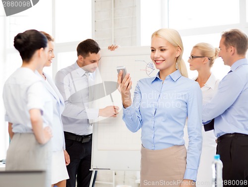 Image of young smiling businesswoman with smartphone