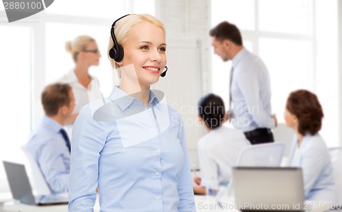 Image of friendly female helpline operator with headphones