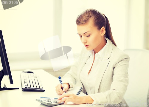 Image of businesswoman with notebook and calculator