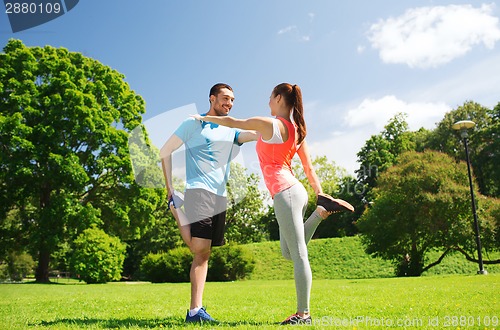 Image of smiling couple stretching outdoors