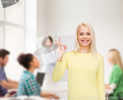 Image of young businesswoman showing ok sign