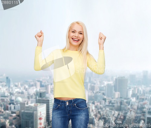 Image of laughing young woman with hands up