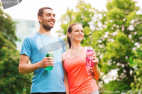 Image of smiling couple with bottles of water outdoors