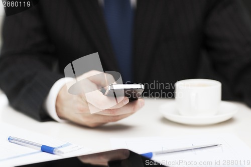 Image of businessman with smartphone reading news