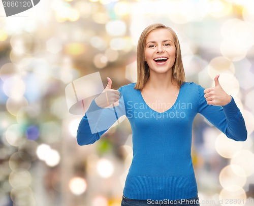 Image of smiling girl in casual clothes showing thumbs up