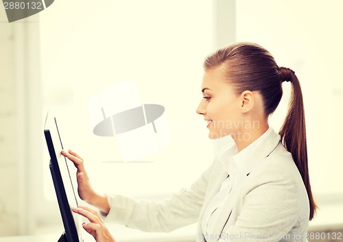 Image of smiling businesswoman with touchscreen in office