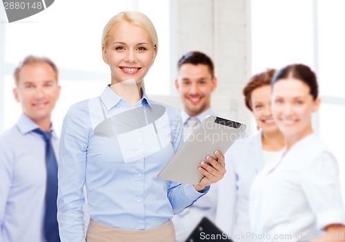 Image of smiling woman looking at tablet pc computer
