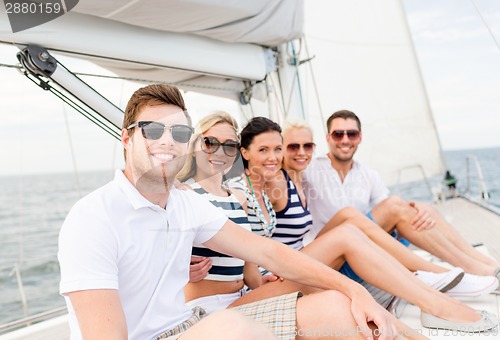 Image of smiling friends sitting on yacht deck