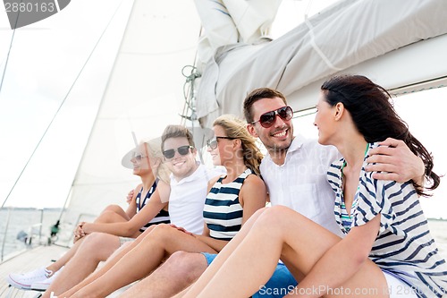 Image of smiling friends sitting on yacht deck