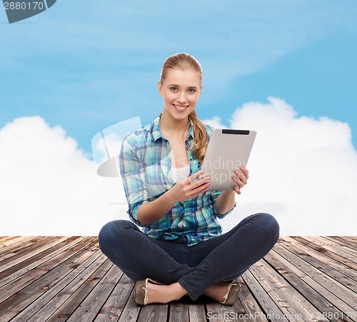 Image of young woman in casual clothes sitting on floor
